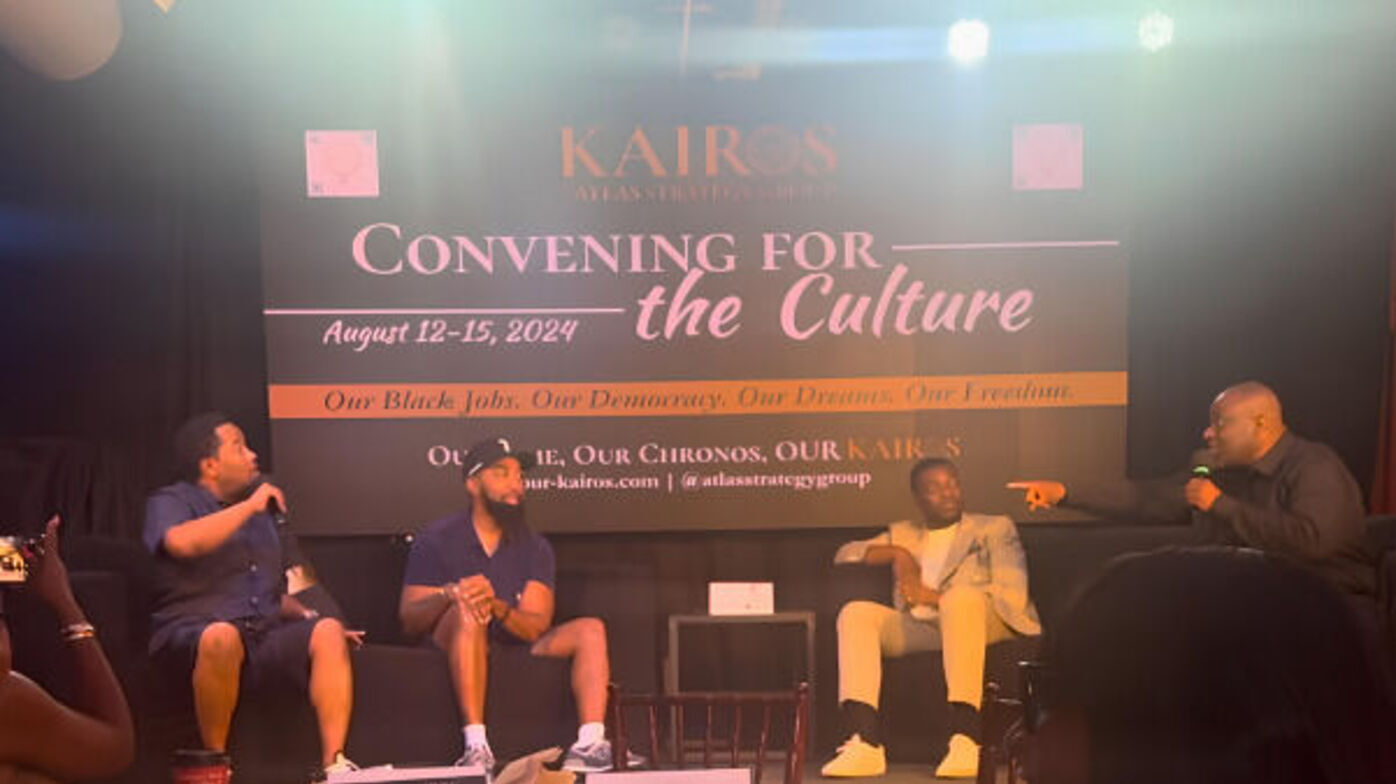 The image captures a panel discussion at the 2024 